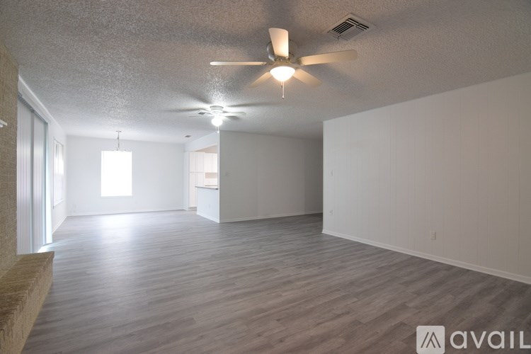 A spacious room with a ceiling fan and lighting fixtures.