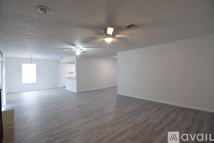 A spacious room with wooden flooring and a white ceiling.