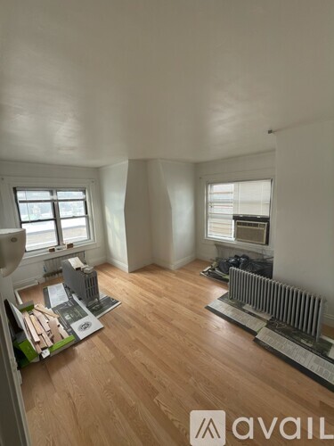 A room with wooden floors and a model of a building on the floor.