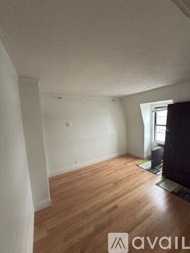 A room with wooden floors and a window.