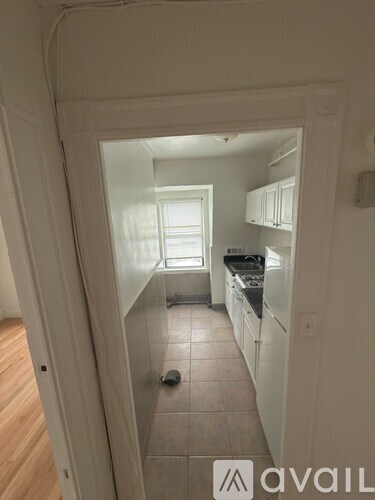 A kitchen with white cabinets and a tiled floor.