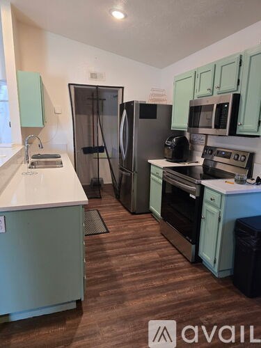 A kitchen with a refrigerator, oven, and sink.