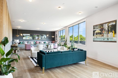 A living room with a green couch and a large window.