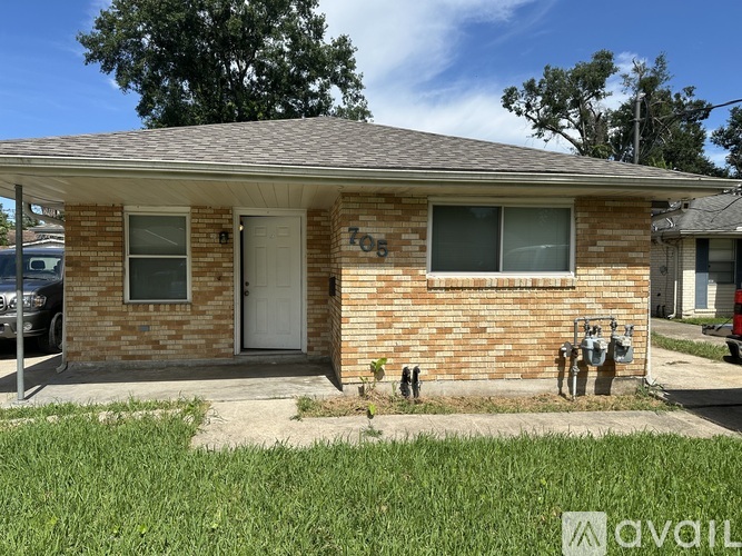A house with a brick facade and a white door is for sale.