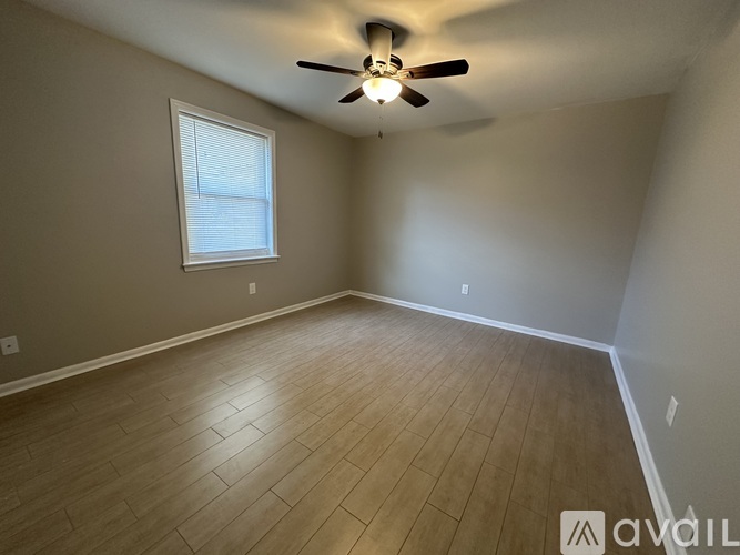 A room with a ceiling fan and a window.