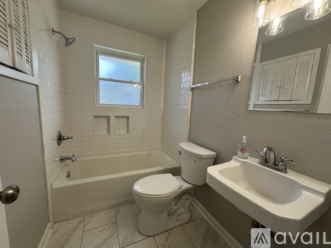 A bathroom with a toilet, sink, and bathtub.