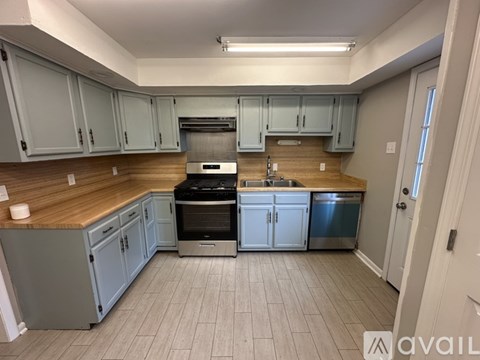 A kitchen with a white stove and blue cabinets.