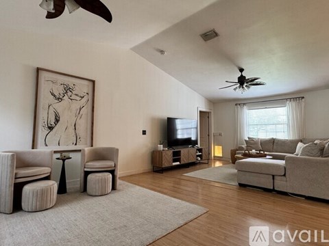 A living room with a television, a couch, and a painting on the wall.
