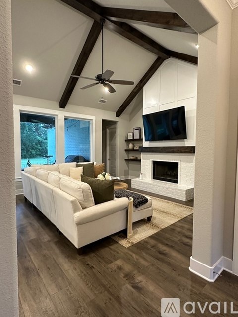 A living room with a white couch and a fireplace.