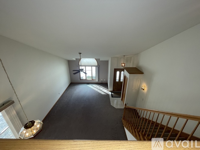 A spacious room with a staircase and a window.