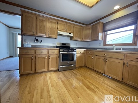 A kitchen with wooden cabinets and a stainless steel oven.