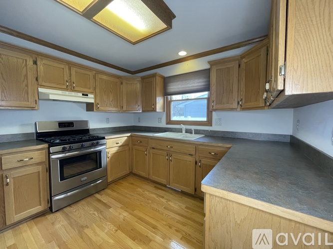 A kitchen with wooden cabinets and a stainless steel stove.