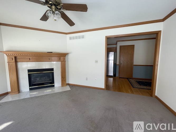 A living room with a fireplace and a ceiling fan.