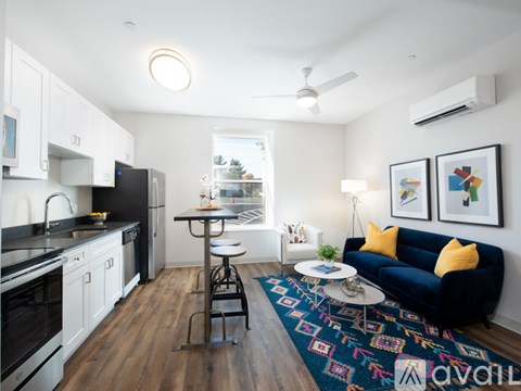 A kitchen with a black fridge and white cabinets.