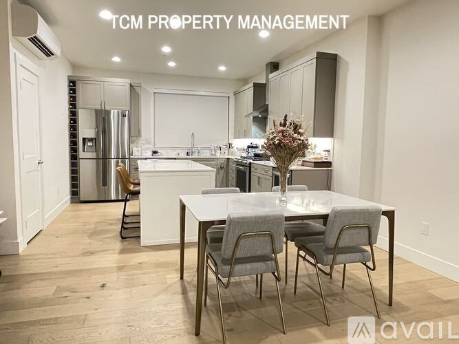 A modern kitchen with a dining table set for two.