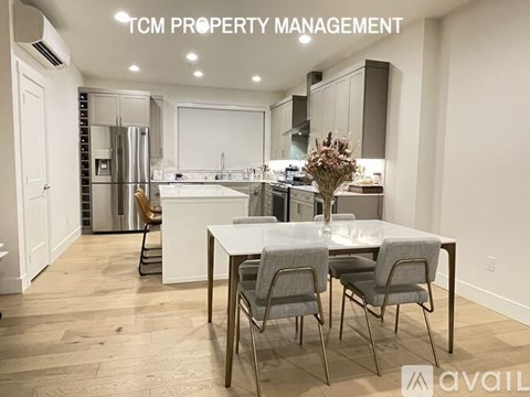 A modern kitchen with a dining table set for two.
