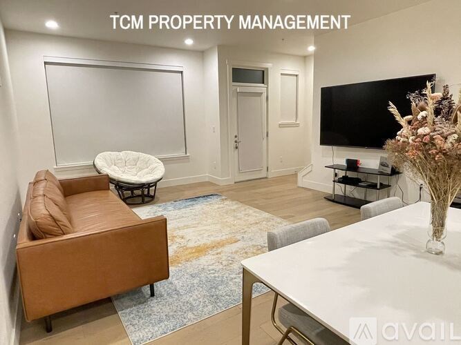 A living room with a couch, a chair, a coffee table, and a television.
