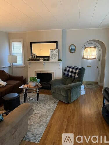 A living room with a fireplace and a mirror above it.