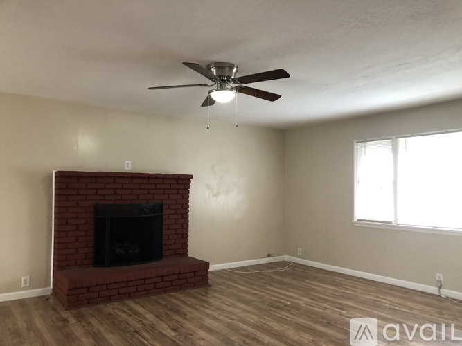 A room with a fireplace and a ceiling fan.
