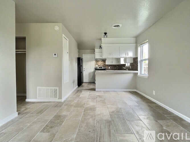 A spacious kitchen and living room with a tile floor.