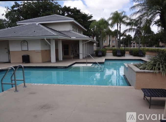 A pool in front of a house with a metal ladder.