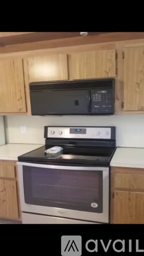 A black microwave oven is mounted above a stove in a kitchen.