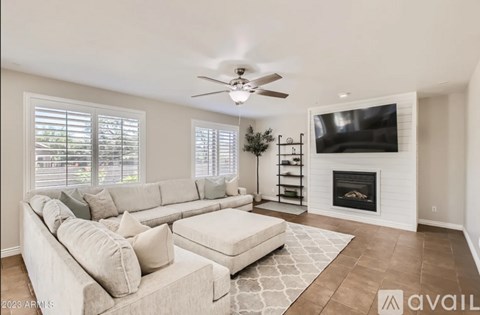 A living room with a fireplace and a television on the wall.