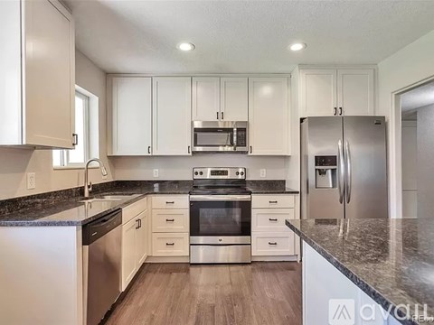 A kitchen with white cabinets and stainless steel appliances.