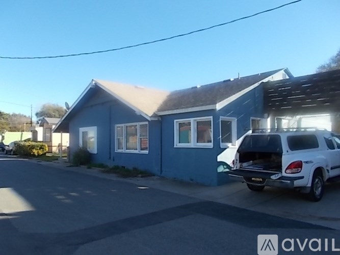 A blue house with a car parked in front.
