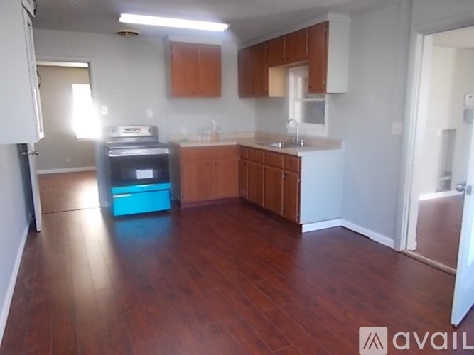A kitchen with wooden floors and a blue oven.