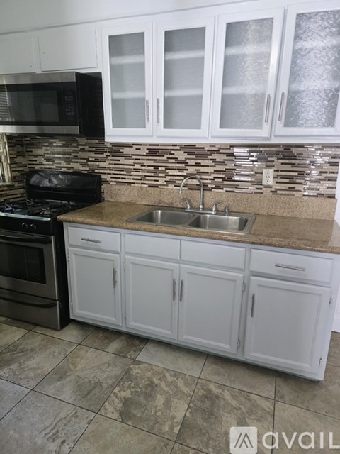 A kitchen with white cabinets and a black stove top oven.
