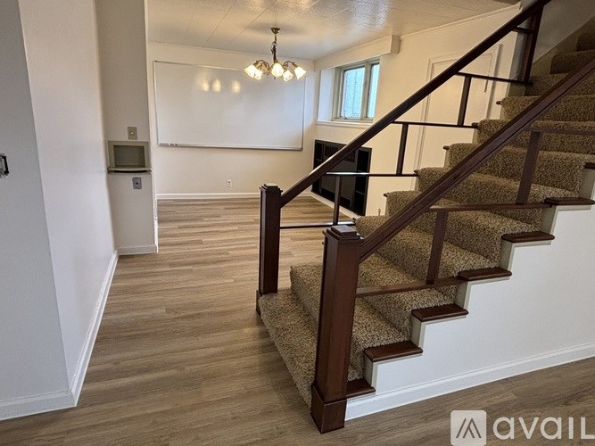 A staircase with a carpeted runner and wooden handrails.
