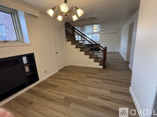 A room with wooden flooring and a staircase.