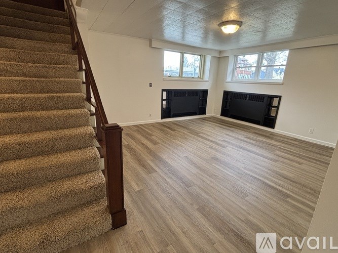 A room with a staircase and a fireplace.