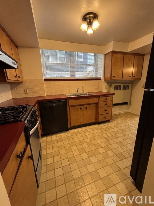 A kitchen with a black fridge, black stove and black dishwasher.