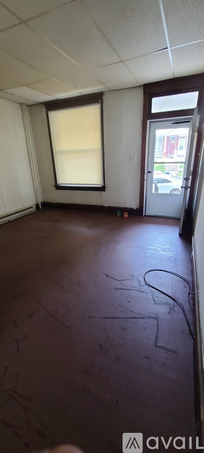 A room with a brown floor and a window.