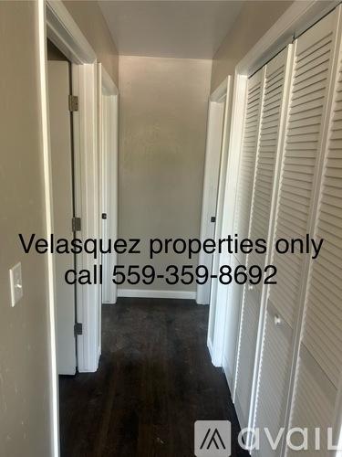 A hallway with white shutters on the doors and a sign that says Velasquez properties only.