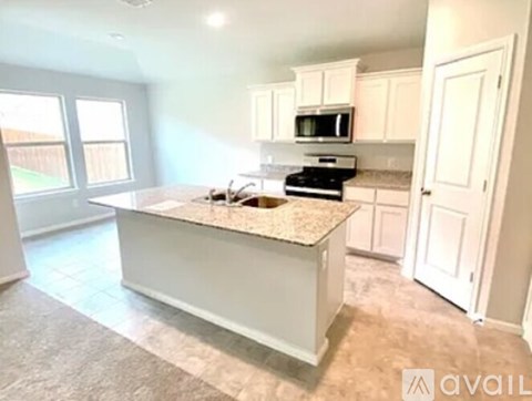 A kitchen with a granite countertop and white cabinets.
