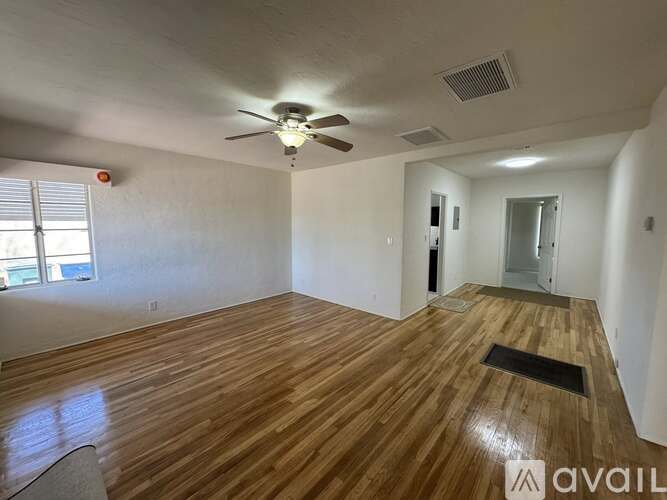 A room with wooden flooring and a ceiling fan.