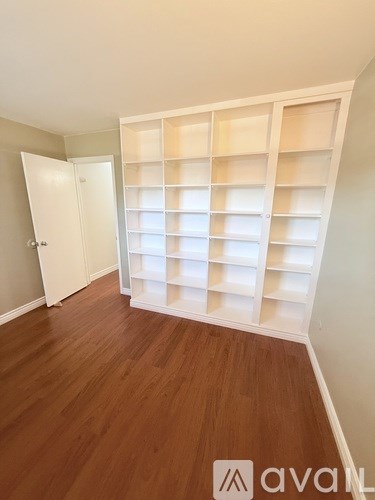 A pool surrounded by a fence and a parking lot.