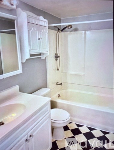 A white bathroom with a black and white checkered floor.