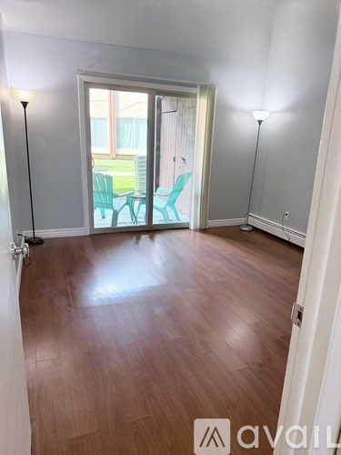 A room with wooden floors and a white floor lamp.