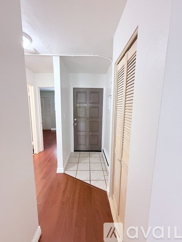 A room with a lamp, a window with curtains, and a wall with a small hole.