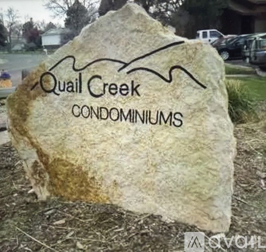 A rock with the words "Quail Creek Condominiums" written on it.