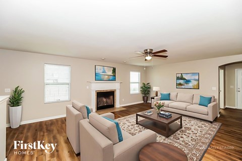 A living room with a fireplace and a painting on the wall.