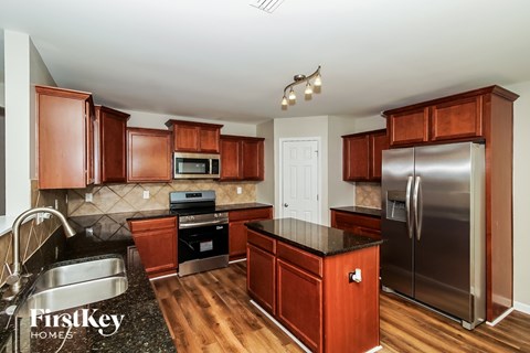 A kitchen with wooden cabinets and a stainless steel refrigerator.