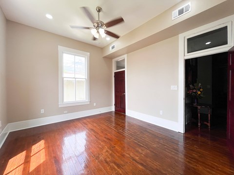 A room with a ceiling fan and a window.