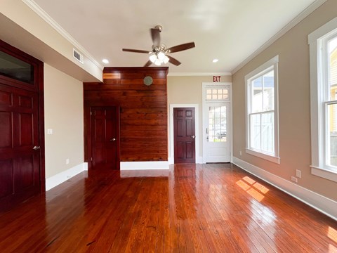 A room with wooden floors and a ceiling fan.