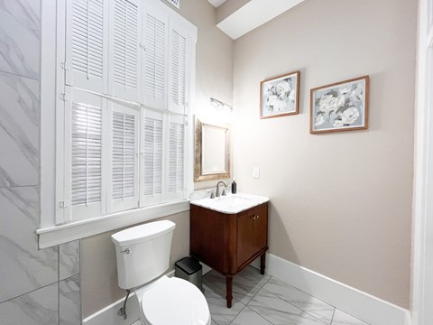 A white toilet sits next to a sink in a bathroom.