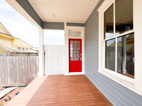A red door is on the side of a house.